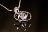 Dimensional atom pendant in sterling silver with crystal center, includes a silver chain,