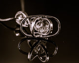 Dimensional atom pendant in sterling silver with crystal center, includes a silver chain,
