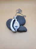 Cowrie shell pendant featuring a sterling silver Adinkra symbol known as Gye Nyame.